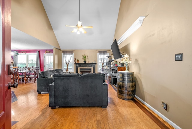 living room featuring ceiling fan, light wood-type flooring, and high vaulted ceiling