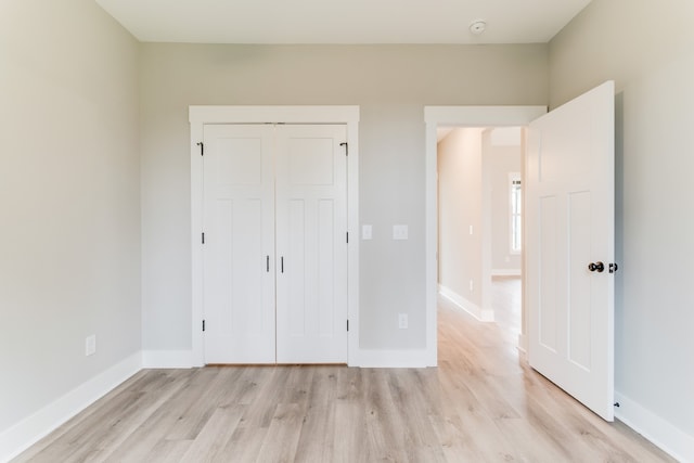 unfurnished bedroom featuring light hardwood / wood-style flooring and a closet