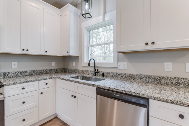 kitchen featuring light stone counters, stainless steel dishwasher, sink, light hardwood / wood-style floors, and white cabinetry