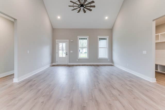 unfurnished living room featuring ceiling fan, high vaulted ceiling, and light hardwood / wood-style flooring