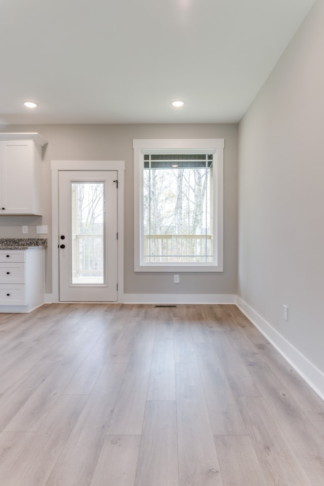 unfurnished living room featuring light hardwood / wood-style floors and a wealth of natural light