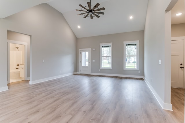 unfurnished living room with ceiling fan, light hardwood / wood-style flooring, and high vaulted ceiling