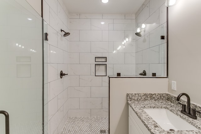 bathroom with vanity and a shower with door