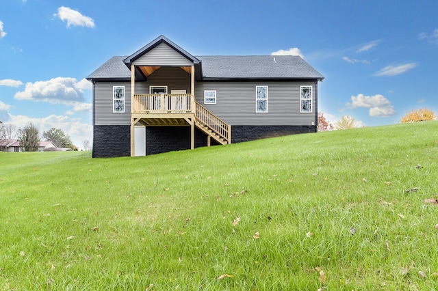 rear view of house featuring a deck and a lawn