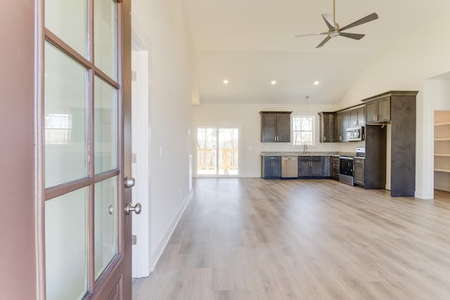 kitchen featuring light hardwood / wood-style floors, ceiling fan, stainless steel appliances, vaulted ceiling, and dark brown cabinetry