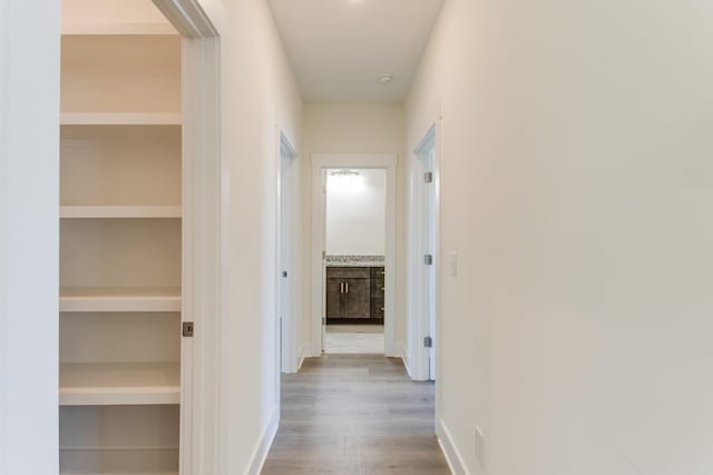 hall with built in features and light wood-type flooring