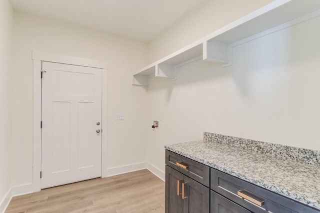 laundry room featuring light hardwood / wood-style floors, washer hookup, and cabinets