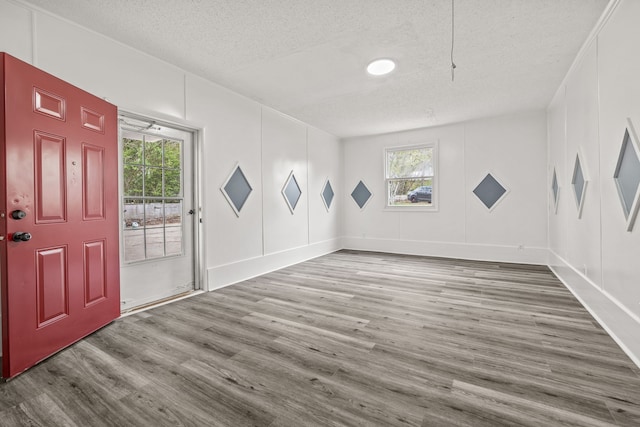 empty room with wood-type flooring and a textured ceiling