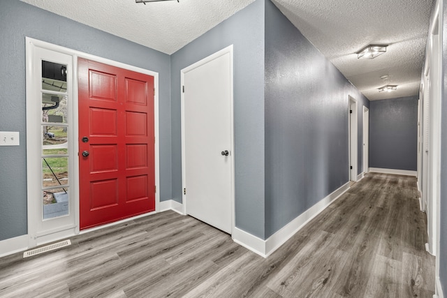 entrance foyer featuring wood-type flooring and a textured ceiling