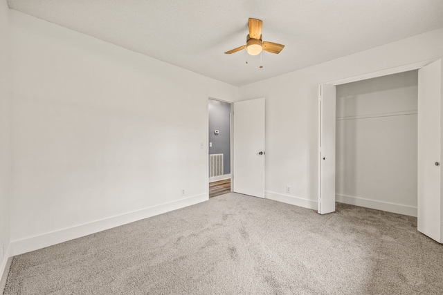 unfurnished bedroom with carpet floors, ceiling fan, and a closet