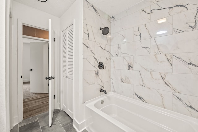 bathroom with tiled shower / bath combo, a textured ceiling, and tile patterned flooring