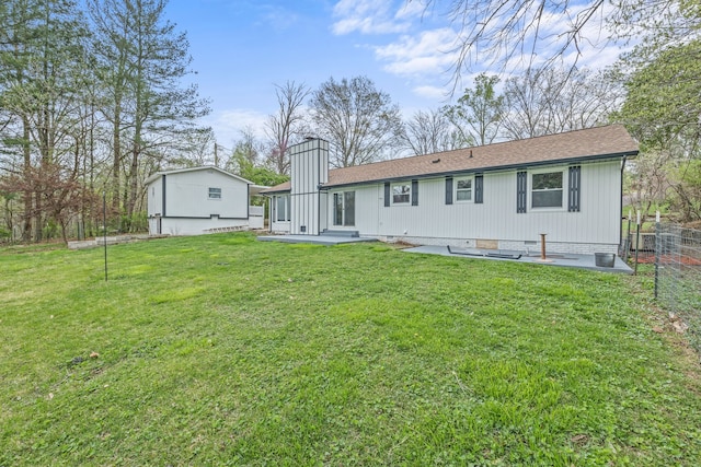 back of property with a patio area and a lawn