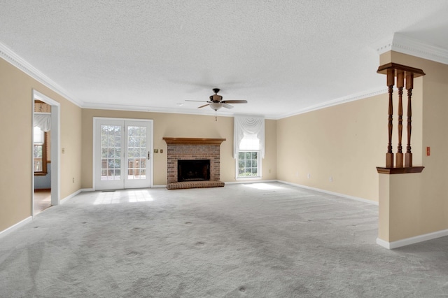 unfurnished living room with light colored carpet, a textured ceiling, ceiling fan, crown molding, and a fireplace