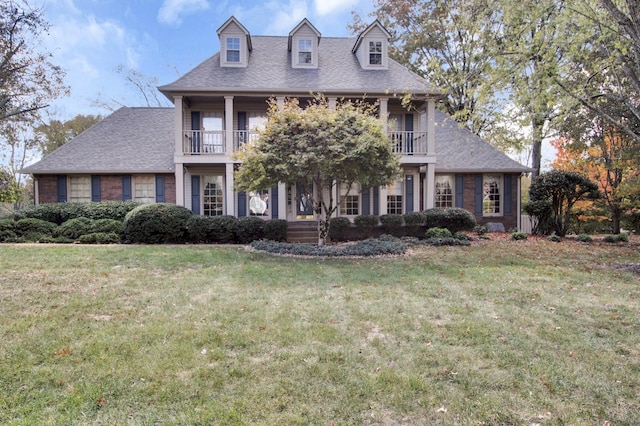 view of front of property with a front lawn and a balcony