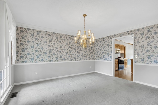 carpeted empty room featuring ornamental molding and a chandelier