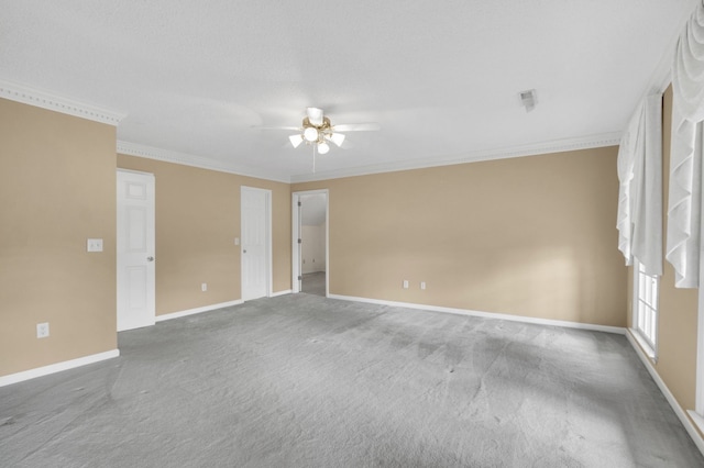 carpeted spare room with ceiling fan and crown molding