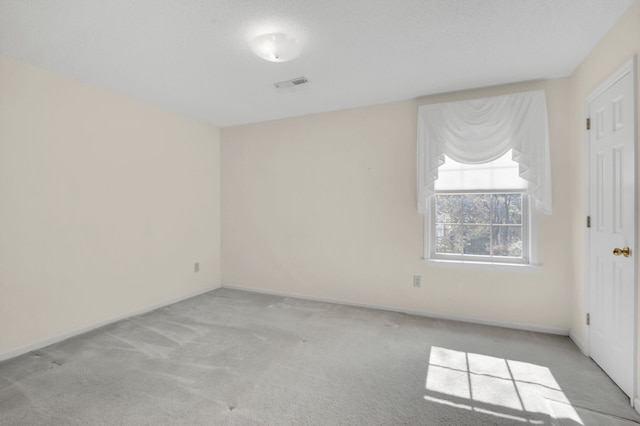 carpeted spare room featuring a textured ceiling