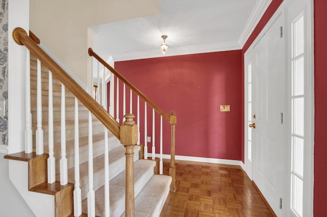 foyer entrance featuring a textured ceiling, crown molding, dark parquet flooring, and plenty of natural light