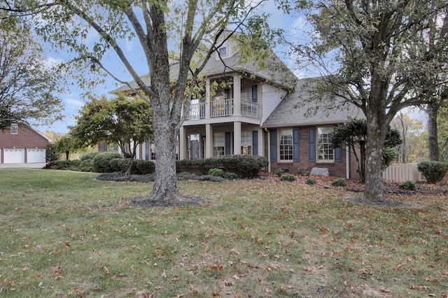 view of front of house featuring a front lawn and a balcony