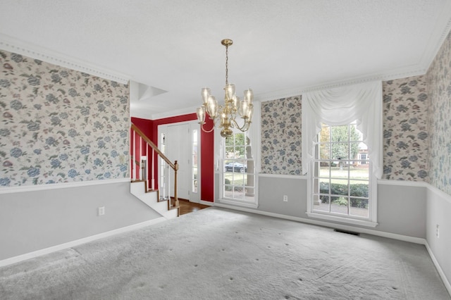 carpeted spare room featuring a textured ceiling, a notable chandelier, and crown molding