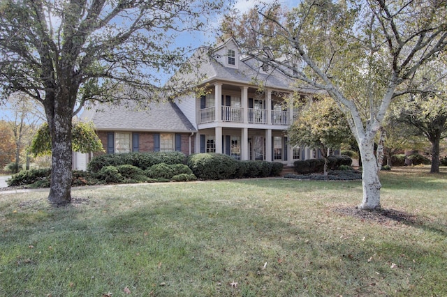 view of front of home with a front yard and a balcony