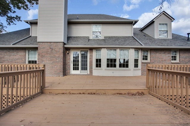 rear view of property featuring a wooden deck