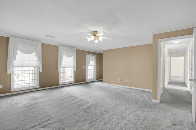 carpeted spare room featuring ceiling fan, a textured ceiling, and ornamental molding