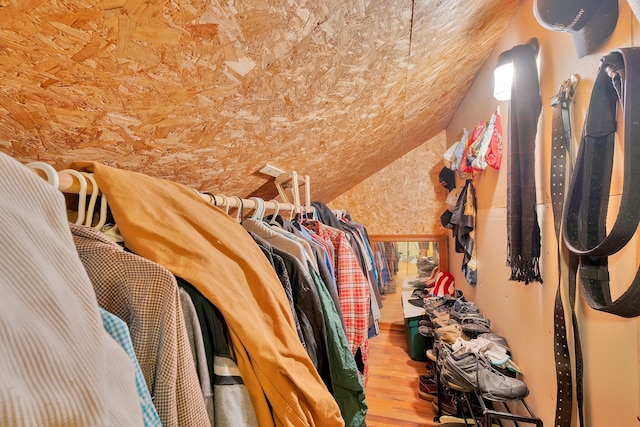 walk in closet with wood-type flooring and lofted ceiling