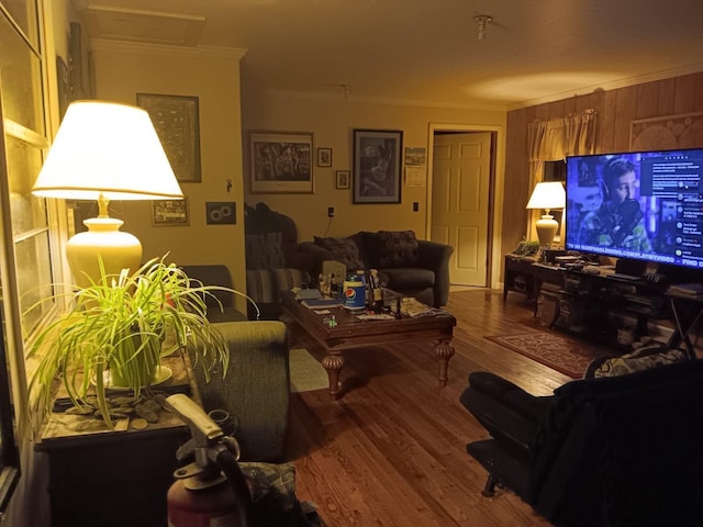 living room with hardwood / wood-style floors, wood walls, and ornamental molding