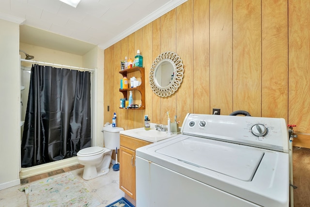 laundry area featuring wood walls, washer / dryer, and crown molding