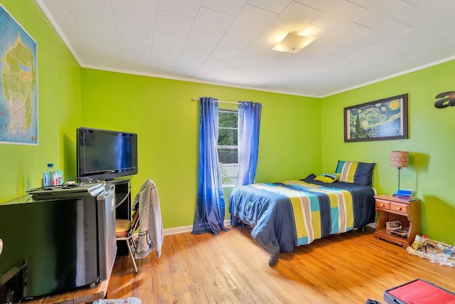 bedroom with wood-type flooring and crown molding