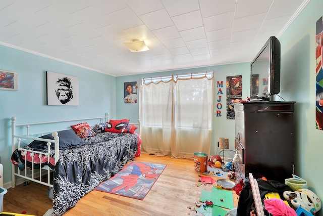 bedroom with hardwood / wood-style floors and crown molding