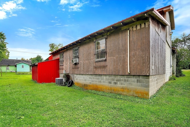 view of side of property with central air condition unit and a yard