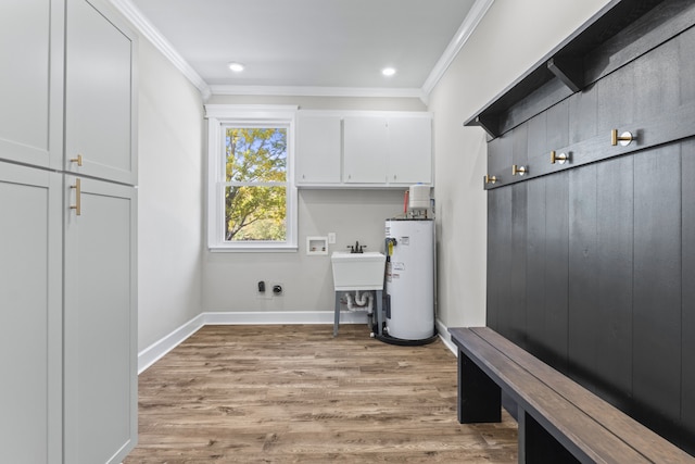 laundry room featuring cabinets, water heater, crown molding, light hardwood / wood-style flooring, and hookup for a washing machine