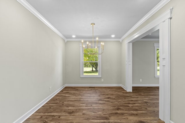 unfurnished dining area with plenty of natural light, dark wood-type flooring, crown molding, and a notable chandelier