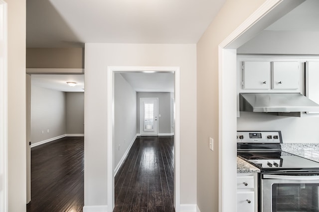 kitchen with white cabinets, stainless steel range with electric cooktop, dark hardwood / wood-style floors, and range hood