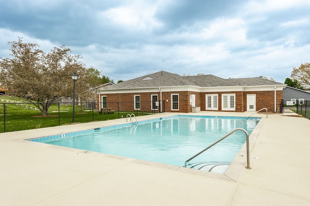 view of pool with a patio area and a yard