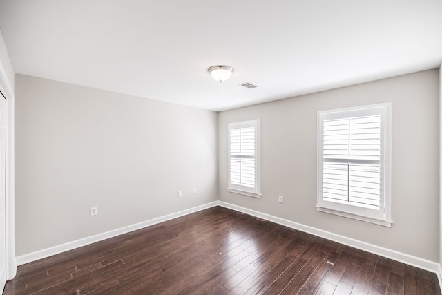 empty room with dark hardwood / wood-style flooring