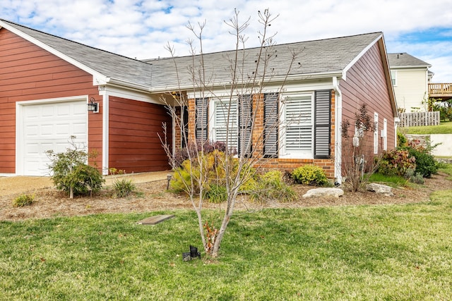 ranch-style home featuring a garage and a front lawn