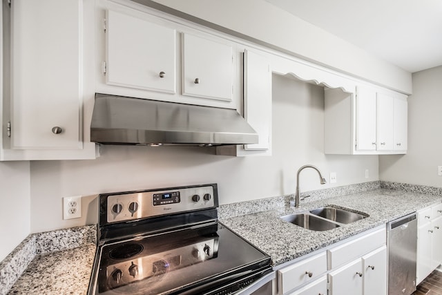 kitchen with sink, dark hardwood / wood-style floors, light stone counters, white cabinetry, and stainless steel appliances