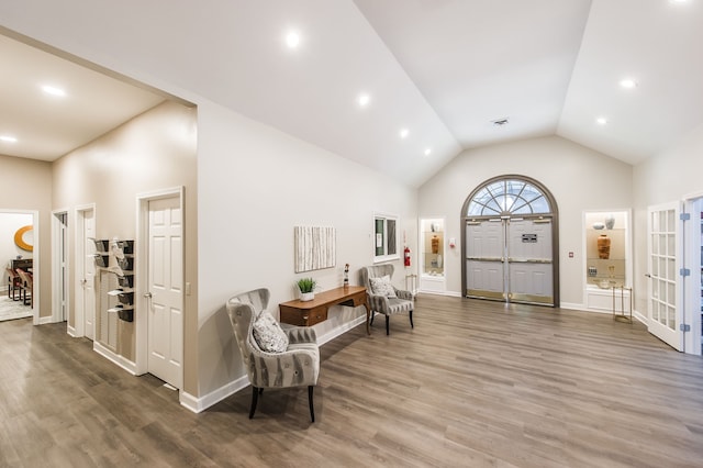 sitting room featuring high vaulted ceiling and hardwood / wood-style flooring