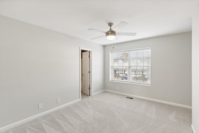 empty room with ceiling fan and light colored carpet