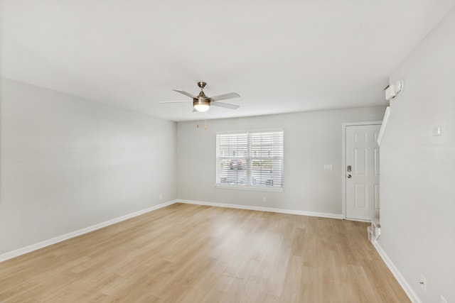 empty room with ceiling fan and light hardwood / wood-style flooring