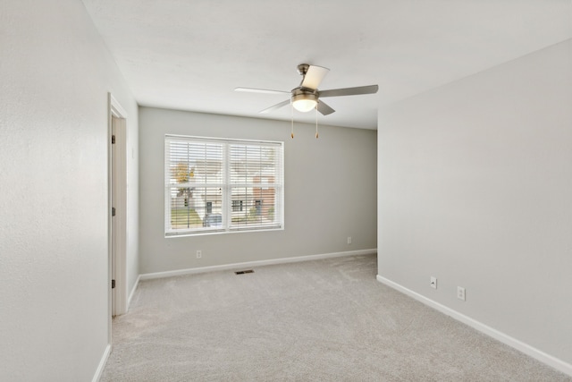 spare room with ceiling fan and light carpet