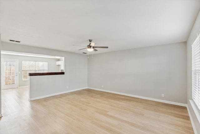 empty room with ceiling fan and light hardwood / wood-style flooring