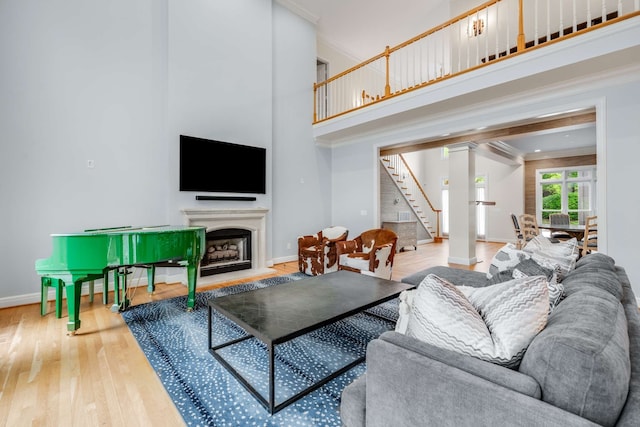 living room featuring a high ceiling, wood-type flooring, and crown molding