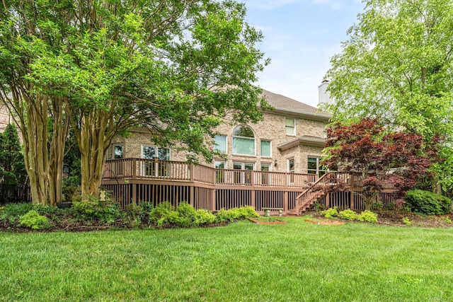 rear view of house with a lawn and a wooden deck