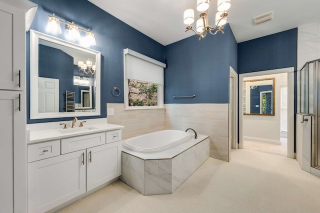 bathroom featuring independent shower and bath, vanity, and an inviting chandelier