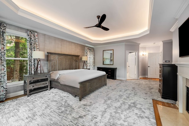 bedroom with ornamental molding, a tray ceiling, and ceiling fan