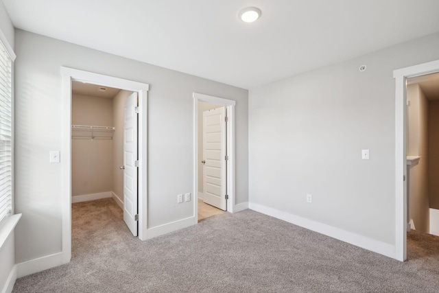 7026 Magnolia Crossings, Spring Hill, TN 37174 - unfurnished bedroom with carpet flooring, a closet, baseboards, and a walk in closet